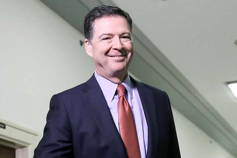 Former FBI Director James Comey smiles for the camera before testifying to the House Judiciary and Oversight and Government Reform committees on Dec. 17 in Washington.